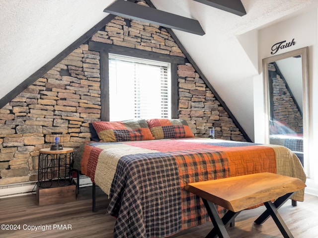 bedroom featuring lofted ceiling with beams and wood finished floors