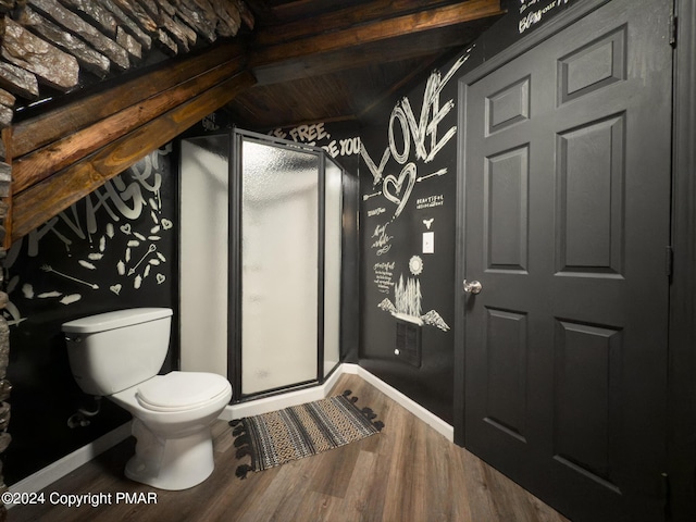 full bathroom with baseboards, wood finished floors, toilet, and a shower stall