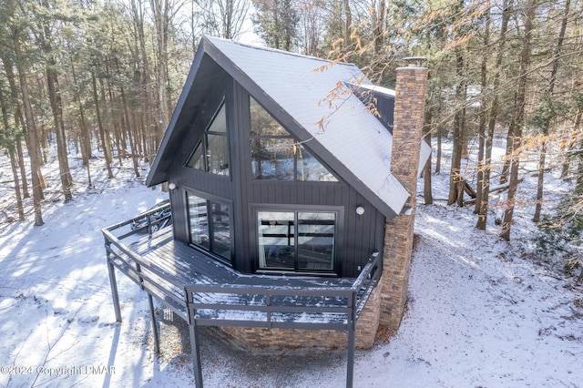 view of snowy exterior featuring a wooden deck