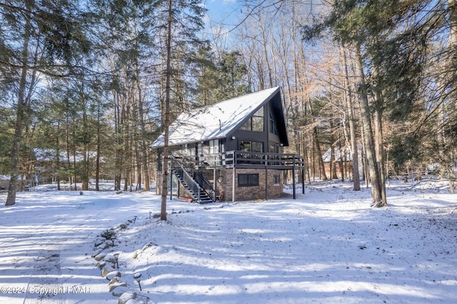 exterior space with stairs, stone siding, and a deck