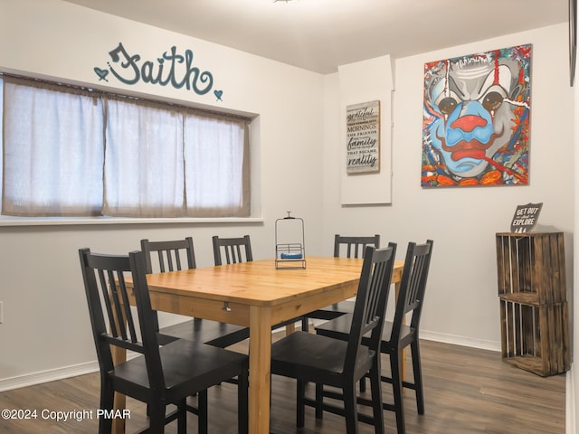 dining space with dark wood-style flooring and baseboards