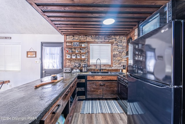 kitchen with black appliances, a textured ceiling, dark wood-type flooring, and a sink