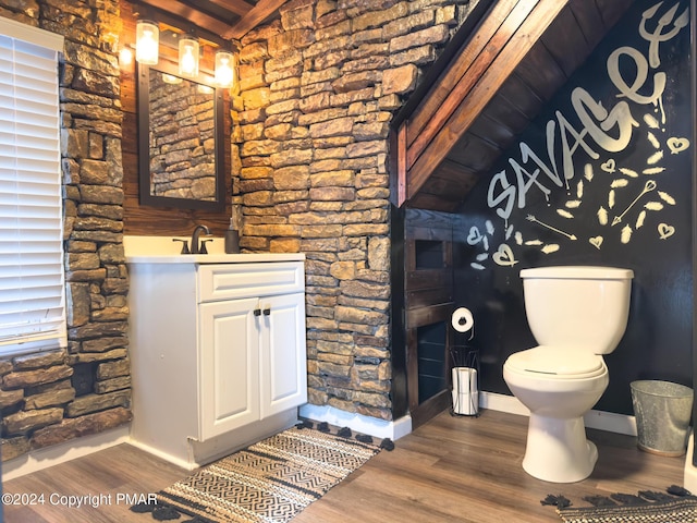 bathroom featuring toilet, baseboards, wood finished floors, and vanity