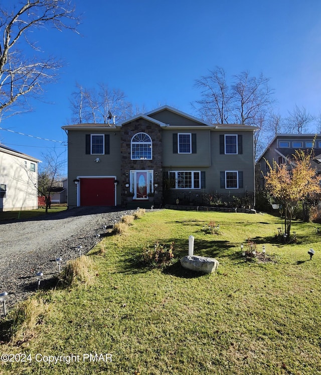 traditional-style house with a front yard, a garage, and driveway