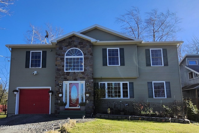 view of front of home with stone siding, driveway, an attached garage, and a front lawn