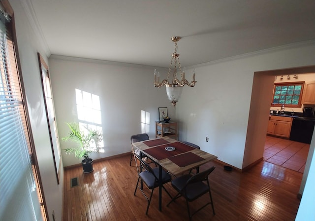 dining space with wood-type flooring, baseboards, a chandelier, and ornamental molding