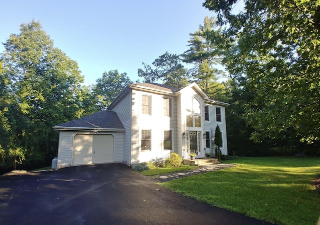 view of front of property featuring a front yard, an attached garage, and driveway