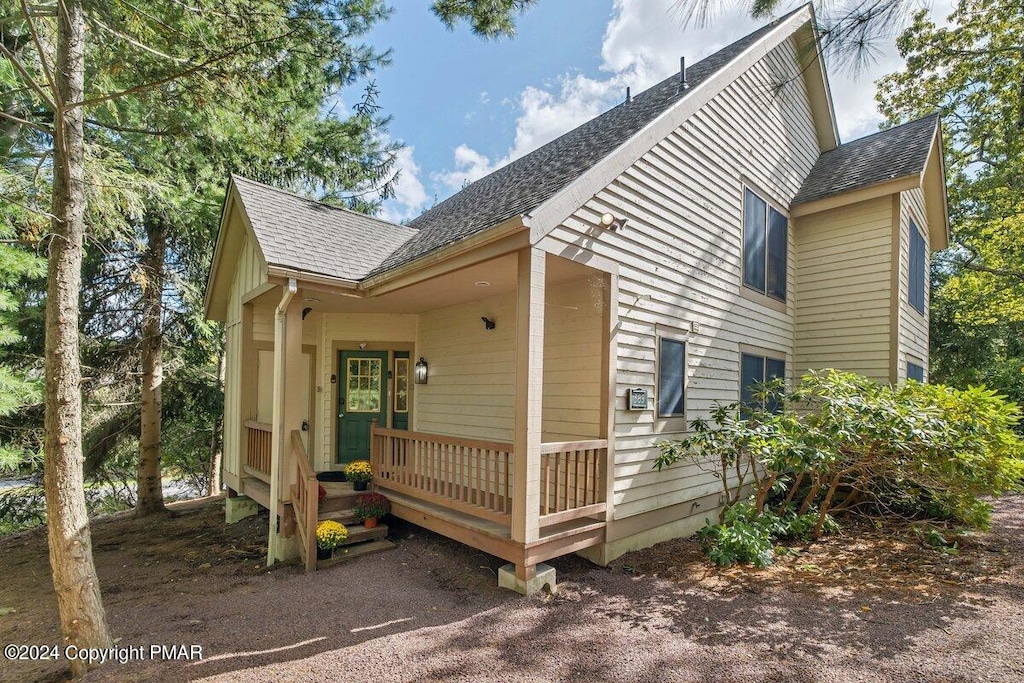 exterior space featuring roof with shingles