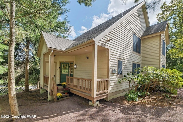 exterior space featuring roof with shingles