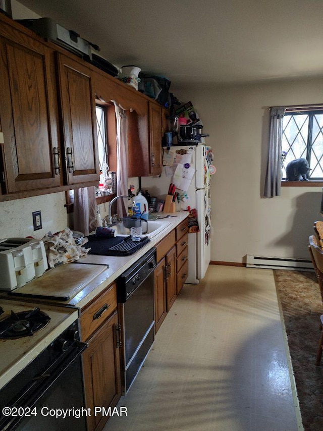 kitchen with a sink, a baseboard heating unit, black dishwasher, range with gas cooktop, and light countertops