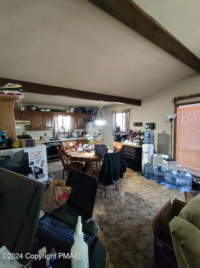 carpeted dining space with vaulted ceiling with beams