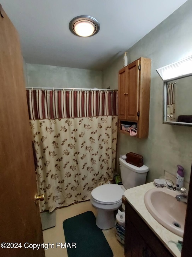 bathroom with toilet, vanity, and a shower with curtain