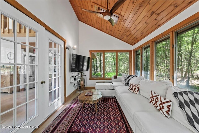 sunroom featuring lofted ceiling, wood ceiling, a healthy amount of sunlight, and ceiling fan