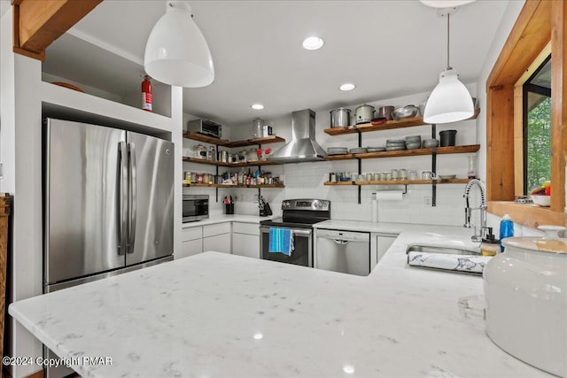 kitchen featuring tasteful backsplash, stainless steel appliances, wall chimney range hood, open shelves, and a sink