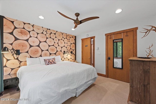 bedroom with ceiling fan, recessed lighting, light carpet, an accent wall, and baseboards