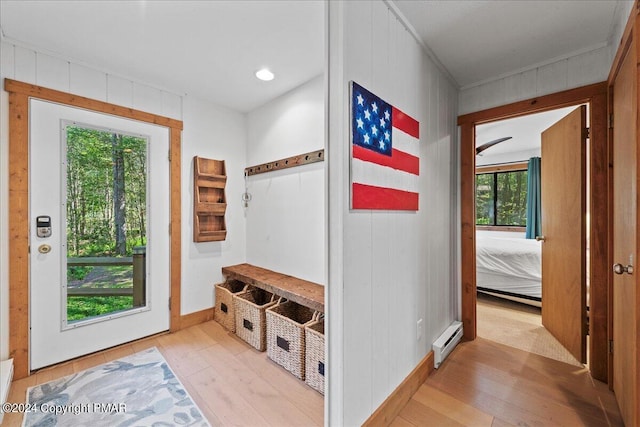 mudroom with wood walls, a baseboard radiator, and wood-type flooring