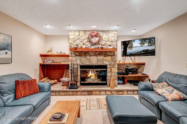 living area featuring a stone fireplace and a textured ceiling