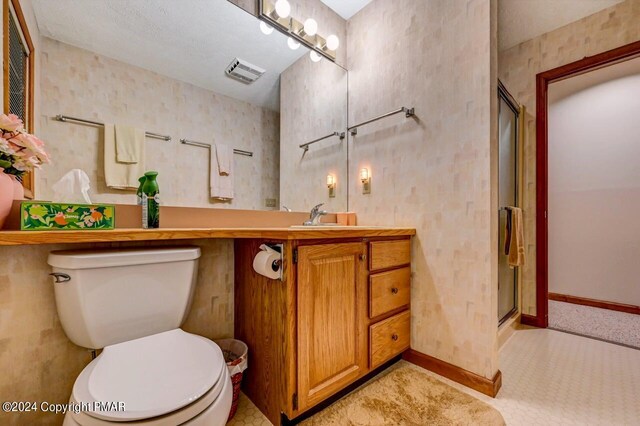 full bathroom featuring visible vents, toilet, a stall shower, baseboards, and vanity