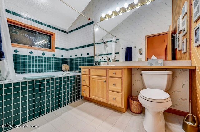 bathroom with vanity, a tile shower, vaulted ceiling, a relaxing tiled tub, and toilet