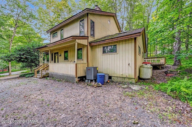 back of house featuring covered porch and central AC