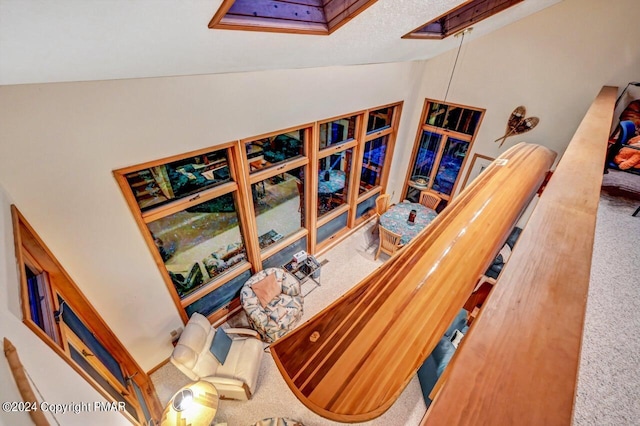 stairway featuring lofted ceiling and carpet flooring