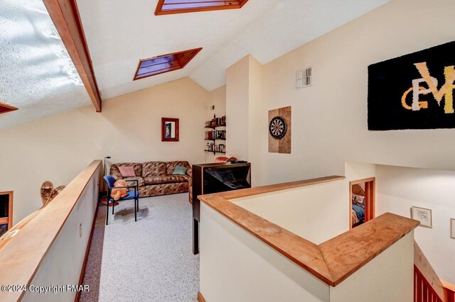 living area with lofted ceiling with skylight, visible vents, and carpet floors