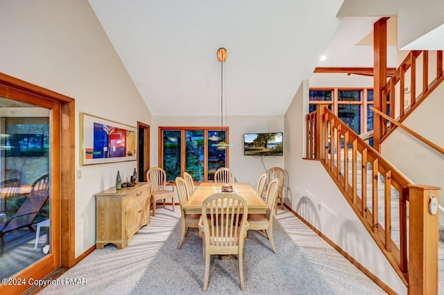 carpeted dining area featuring baseboards and lofted ceiling