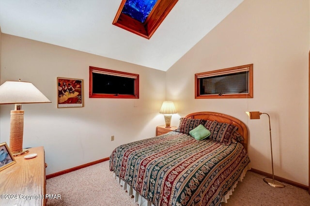 bedroom featuring baseboards, vaulted ceiling with skylight, and carpet