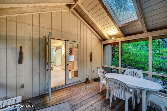 sunroom / solarium with vaulted ceiling with skylight