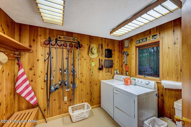 laundry room featuring washer and dryer, wood walls, and laundry area