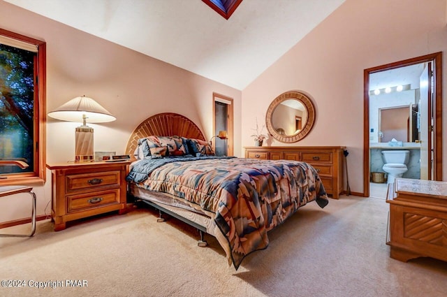 bedroom featuring light colored carpet, ensuite bath, baseboards, and vaulted ceiling