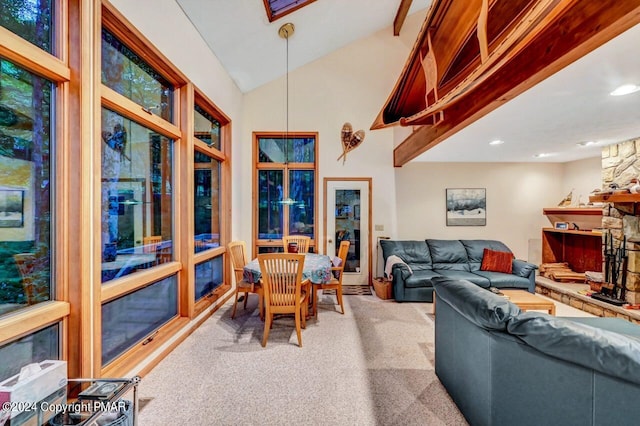 carpeted living room with a stone fireplace and lofted ceiling