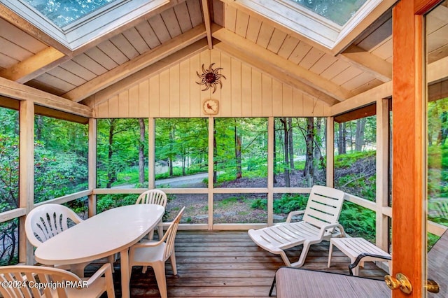 sunroom with lofted ceiling with skylight and plenty of natural light