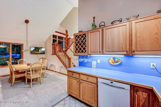 kitchen featuring light countertops, vaulted ceiling, light carpet, white dishwasher, and hanging light fixtures