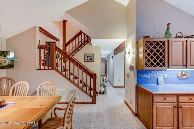 kitchen featuring lofted ceiling, light colored carpet, baseboards, and light countertops