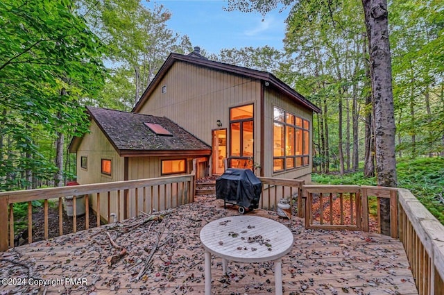 wooden deck with area for grilling and a sunroom