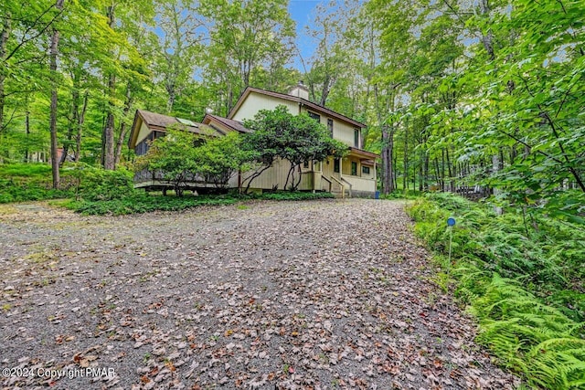 view of front of property featuring driveway and a chimney