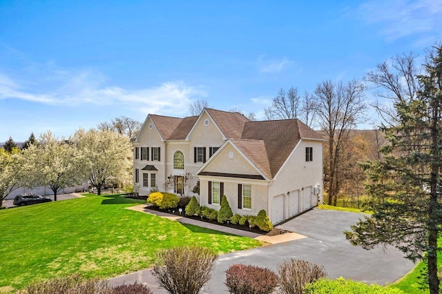 view of front facade featuring stucco siding, driveway, and a front yard