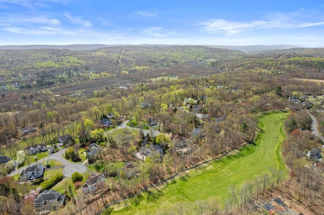 birds eye view of property featuring golf course view, a mountain view, and a wooded view