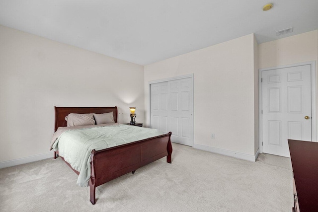 bedroom with baseboards, a closet, visible vents, and light carpet