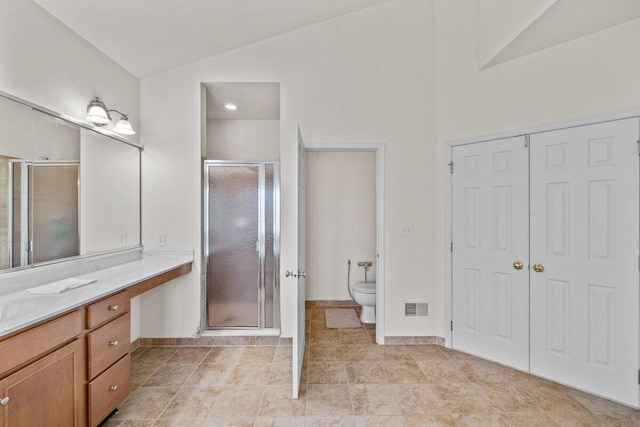 full bath featuring vanity, toilet, vaulted ceiling, visible vents, and a stall shower