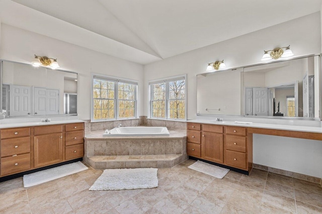 full bath featuring vaulted ceiling, two vanities, and a sink