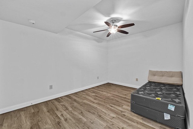 unfurnished bedroom featuring a ceiling fan, baseboards, and wood finished floors