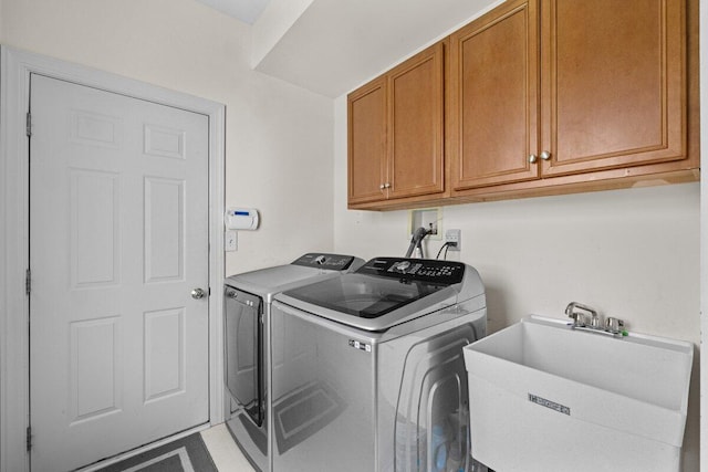 laundry area featuring a sink, cabinet space, and washing machine and clothes dryer