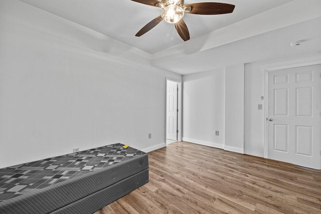 unfurnished bedroom featuring baseboards, a ceiling fan, and wood finished floors