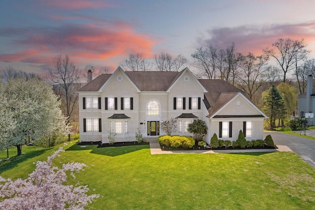 view of front of house featuring a chimney and a front yard