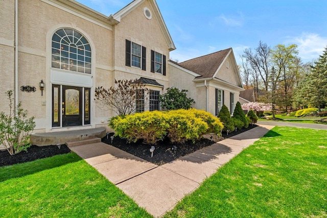 property entrance with a yard and stucco siding