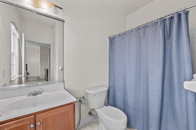bathroom featuring toilet, curtained shower, and vanity