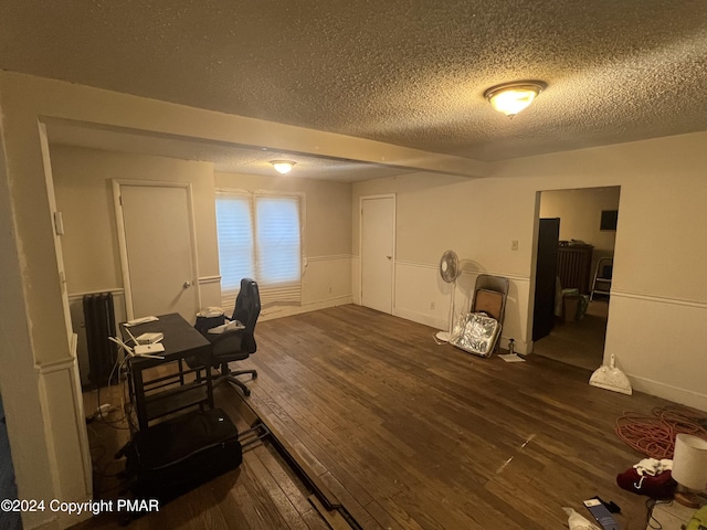 office space featuring a wainscoted wall, a textured ceiling, and dark wood-style floors