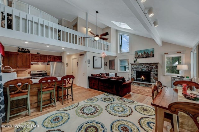 living room featuring light wood-style floors, a healthy amount of sunlight, and a ceiling fan